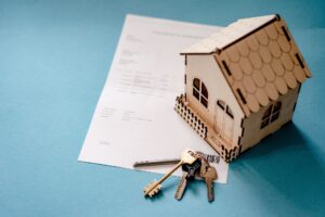 minature house with a set of keys on top of paper